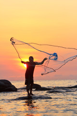 throwing fishing net during sunrise, Thailand