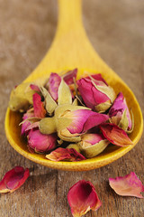 Obraz na płótnie Canvas tea rose flowers in wooden spoon