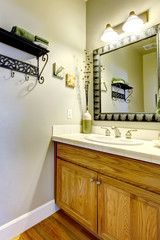 Small bathroom sink and cabinet with green wall.