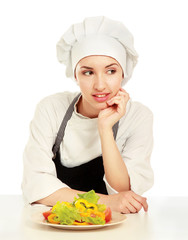 Pretty cook chief sitting on the table with salad