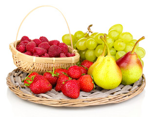 ripe sweet fruits and berries on wicker mat isolated on white