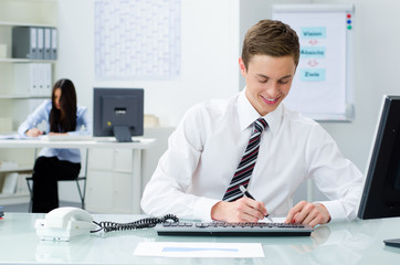 auszubildender sitzt am arbeitsplatz