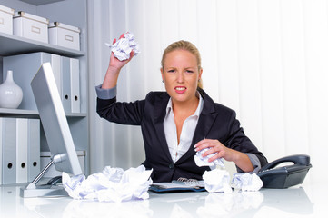 Frau im Büro mit zerknülltem Papier