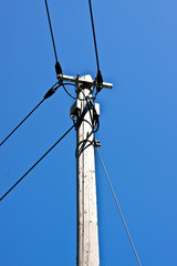 Alter Telefonmast vor blauem Himmel