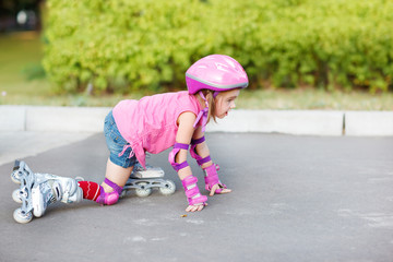 Fototapeta premium Girl in roller skates getting up