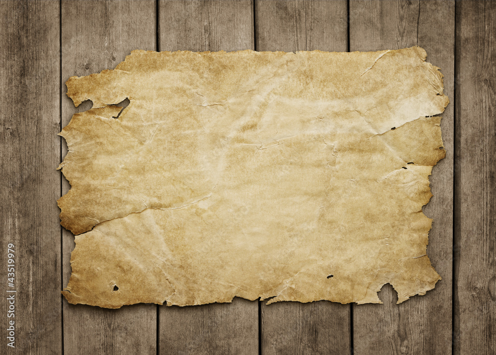 Wall mural Old paper sheet at grunge wooden background