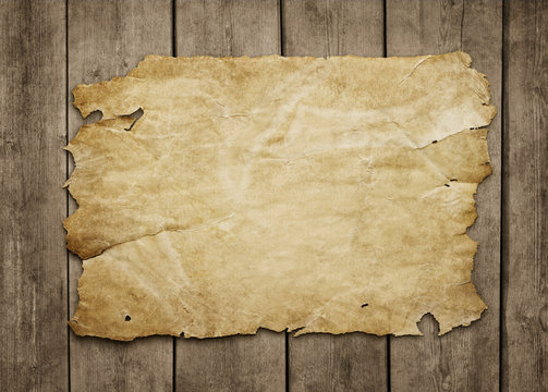 Old paper sheet at grunge wooden background
