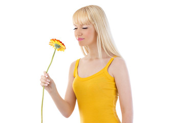 Obraz na płótnie Canvas Attractive blonde woman smelling daisy