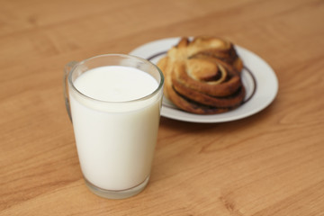 A cup of milk and cinnamon bun