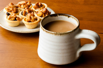 Cup of coffee  with cashew tart.
