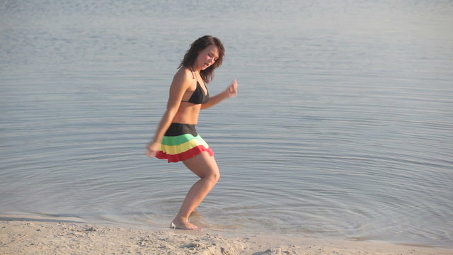 Young beautiful woman dancing in the water  at summer