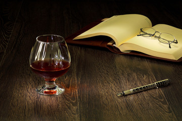 Cognac, cigar and an old book nearby