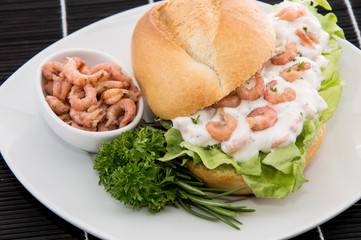 Roll with Shrimp-Salad on a cutting board