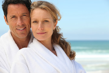 Obraz premium Couple in bathrobes on the beach