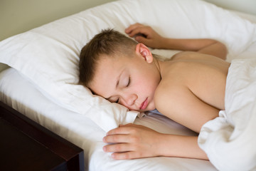 Fototapeta na wymiar Sleeping boy in bed. Morning. Boy is nine years old.