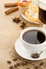 cup of coffee with beans and cakes on wood