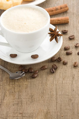 cup of coffee with beans on wood background texture