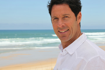 Man smiling at the seaside.