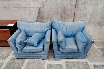 Fauteuils bleus jetés dans la rue. encombrants