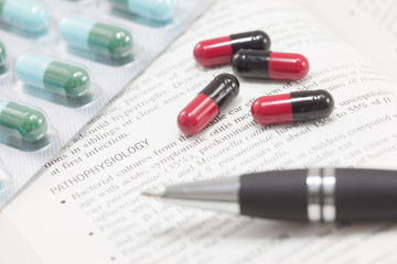 Concept of medical treatment contain many pills and textbook