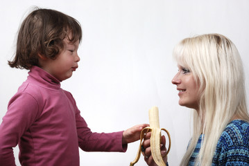 Mom giving a banana to his daughter