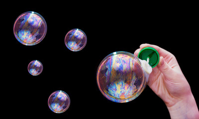 soap bubbles and hand on black