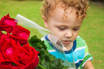 a sad child with a bouquet of red roses