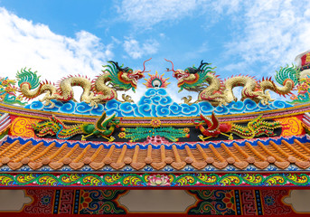 colorful dragon statue on china temple roof with blue sky backgr
