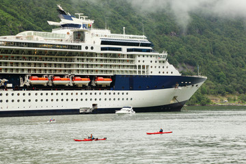 Two kayaks, yacht and rescue boat float on fiord