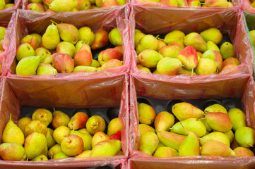 Bunch of fresh pears in boxes in supermarket