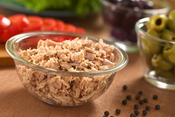 Canned tuna in glass bowl with fresh salad ingredients