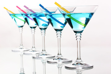 Blue cocktail in martini glasses isolated on white