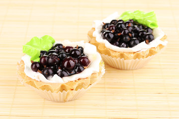 sweet cakes with berries on bamboo mat