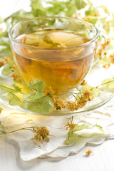 Linden tea in the transparent cup and dry linden flowers
