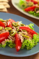 Fresh tuna, tomato and green olive salad on lettuce leaf