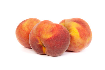 Three tasty juicy peaches on a white background