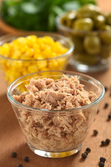 Canned tuna in glass bowl with sweet corn and olives