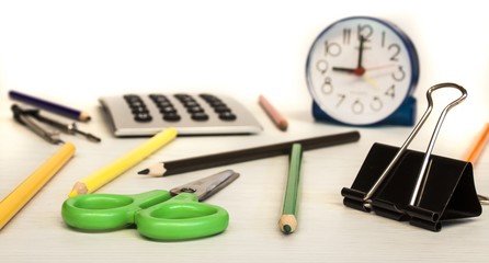 school composition, clock, pencils, calculator,  and scissors