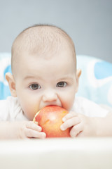 portrait of lovely little caucasian tot eating an apple