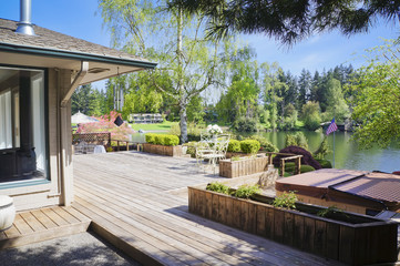 Spring deck and house view with lake and tub.