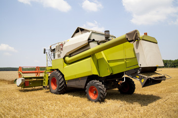 Obraz premium Combine working on a wheat field