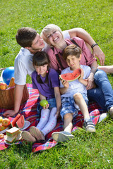 Fototapeta premium Happy family playing together in a picnic outdoors
