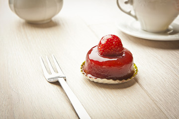 fruit pastry little cake with tea cup on white wooden table