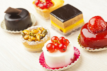 Different sort of beautiful pastry, small colorful sweet cakes