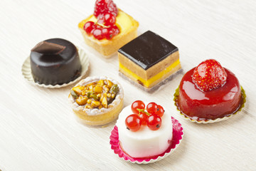 Different sort of beautiful pastry, small colorful sweet cakes