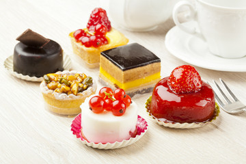 Different sort of beautiful pastry, small colorful sweet cakes