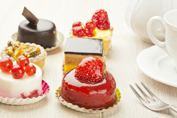 Different sort of beautiful pastry, small colorful sweet cakes