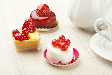 fruit pastry little cake with tea cup on white wooden table