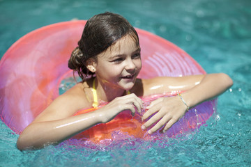 Pretty little girl swimming in outdoor pool 