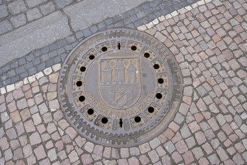 Sewer manhole with ñoat of arms of Prague